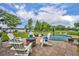Scenic backyard with a fire pit, pool, lush landscaping, and lake views, creating a serene outdoor oasis at 339 Carolyn Dr, Oviedo, FL 32765