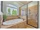 Bathroom featuring a large tub under a window and a large glass shower with a pebble floor at 339 Carolyn Dr, Oviedo, FL 32765