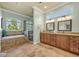 A lavish bathroom with a dual vanity, tiled floors, a tub, a shower, and a large window at 339 Carolyn Dr, Oviedo, FL 32765