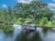 Picturesque boat dock on the lake with cover and lift, surrounded by lush greenery at 339 Carolyn Dr, Oviedo, FL 32765