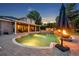 Backyard with a pool, outdoor kitchen, covered patio and an outdoor fireplace, ideal for nighttime gatherings at 339 Carolyn Dr, Oviedo, FL 32765