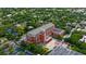 Aerial view of the library and parking lot surrounded by mature trees in a neighborhood at 111 E Monument Ave # 801, Kissimmee, FL 34741