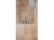 Close up of modern polished chrome bath fixtures with a wall of travertine tile at 111 E Monument Ave # 801, Kissimmee, FL 34741
