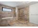 Bright bathroom featuring a tub, walk-in shower with bench, and neutral travertine tile at 111 E Monument Ave # 801, Kissimmee, FL 34741