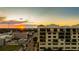 Sunset aerial showcasing a multi-story building with balconies and a vibrant cityscape in the background at 111 E Monument Ave # 801, Kissimmee, FL 34741