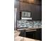 Modern kitchen featuring stainless steel appliances, stylish backsplash, and sleek dark cabinetry at 111 E Monument Ave # 801, Kissimmee, FL 34741
