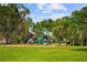 Gathering-friendly playground featuring multiple slides and climbing structures, nestled among lush trees at 111 E Monument Ave # 801, Kissimmee, FL 34741