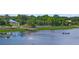 Waterfront view featuring a wooden dock, a fishing boat, and lush green vegetation at 111 E Monument Ave # 801, Kissimmee, FL 34741