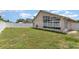 A view of the backyard showing the screen room on the house with a white fence that surrounds the yard at 11715 Sindlesham Ct, Orlando, FL 32837