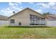 Backyard view showcasing the side of the home with a sunroom addition and well-maintained lawn at 11715 Sindlesham Ct, Orlando, FL 32837