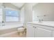 Bright bathroom featuring white subway tiles, a tub/shower, and a large vanity at 11715 Sindlesham Ct, Orlando, FL 32837