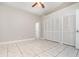 Neutral bedroom with ceiling fan, tile floors, and large closet at 11715 Sindlesham Ct, Orlando, FL 32837