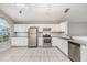 Bright kitchen with white cabinets, stainless steel appliances, granite countertops, and tile flooring at 11715 Sindlesham Ct, Orlando, FL 32837