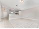 Open concept living room with neutral walls, tile flooring, and a bar overlooking the kitchen at 11715 Sindlesham Ct, Orlando, FL 32837