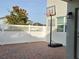 Backyard brick patio with basketball hoop, enclosed by a white fence and mature tree at 11802 Pulitzer Pl, Orlando, FL 32832