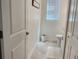 Clean and well-lit powder room with tile flooring, a toilet, and a small vanity at 11802 Pulitzer Pl, Orlando, FL 32832