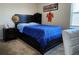 Well-lit bedroom featuring a dark-wood bed frame, blue comforter, and neutral walls at 11802 Pulitzer Pl, Orlando, FL 32832