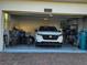 Spacious two-car garage with ample storage, featuring a modern white vehicle at 11802 Pulitzer Pl, Orlando, FL 32832