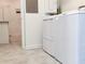 Laundry room featuring tile floors, white walls, and white appliances at 11802 Pulitzer Pl, Orlando, FL 32832