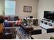 Bright living room featuring a gray sofa, stylish rug, desk and TV on an entertainment center at 11802 Pulitzer Pl, Orlando, FL 32832