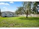 Beautifully landscaped backyard with mature trees and a well-maintained lawn at 1322 Morris Ave, Orlando, FL 32803