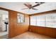 Bedroom features wood paneling, hardwood floors, a bright window, and open access to kitchen at 1322 Morris Ave, Orlando, FL 32803