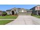 Attractive single-story home with lush landscaping and a spacious driveway at 13478 Summer Rain Dr, Orlando, FL 32828