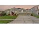 Charming single-story home with a well-manicured lawn and three-car garage at 13478 Summer Rain Dr, Orlando, FL 32828