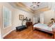Well-lit bedroom featuring hardwood floors, a tray ceiling, and ample space for exercise equipment at 13478 Summer Rain Dr, Orlando, FL 32828