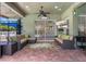 Comfortable covered patio area with cozy seating, a ceiling fan, and a TV, ideal for outdoor relaxation at 13478 Summer Rain Dr, Orlando, FL 32828