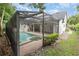 Home's backyard oasis featuring screened-in pool and hot tub, lush landscaping, and privacy at 1350 Lyndale Blvd, Winter Park, FL 32789