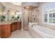 Luxurious bathroom featuring a soaking tub, walk-in shower, and elegant vanity with granite countertop at 1350 Lyndale Blvd, Winter Park, FL 32789