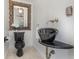 Chic powder room boasts a unique black sink, ornate mirror, and stylish fixtures at 1350 Lyndale Blvd, Winter Park, FL 32789