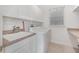 Well-lit laundry room with ample cabinet space, sink, and modern washer and dryer units at 1350 Lyndale Blvd, Winter Park, FL 32789