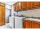 Well-equipped laundry room with modern washer, dryer, sink, granite countertop, and custom storage cabinets at 140 E Morse Blvd # C, Winter Park, FL 32789