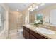Bright bathroom featuring a double vanity, granite counters, and a glass enclosed shower at 14897 Evergreen Oak Loop, Winter Garden, FL 34787