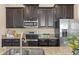 This modern kitchen has dark cabinets, granite counters, and stainless steel appliances at 14897 Evergreen Oak Loop, Winter Garden, FL 34787
