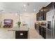 Open concept with kitchen island, stainless appliances, and dark wood cabinets at 14897 Evergreen Oak Loop, Winter Garden, FL 34787