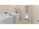 Functional laundry room features washer, dryer, storage shelves, and access to the exterior at 14897 Evergreen Oak Loop, Winter Garden, FL 34787