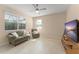 Cozy living room with a sofa, armchair, tile floors, and lots of natural light at 14897 Evergreen Oak Loop, Winter Garden, FL 34787