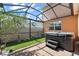 Beautiful screened patio featuring a hot tub, artificial grass, and thoughtful landscaping at 14897 Evergreen Oak Loop, Winter Garden, FL 34787