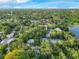 Expansive aerial view of the property showcasing its location in a lush, tree-filled neighborhood near a tranquil lake at 1630 Lakeview Ct, Eustis, FL 32726