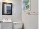 Cozy bathroom featuring a white vanity, toilet, mirror and window for natural light at 1630 Lakeview Ct, Eustis, FL 32726