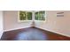 Bright bedroom featuring dark hardwood floors and corner windows with natural light and a view of green trees at 1630 Lakeview Ct, Eustis, FL 32726