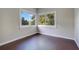 Bright bedroom featuring dark hardwood floors and corner windows with natural light and a view of green trees at 1630 Lakeview Ct, Eustis, FL 32726