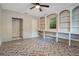 Spacious bedroom with herringbone pattern floors, built-in shelves, ceiling fan, and ample natural light at 1630 Lakeview Ct, Eustis, FL 32726