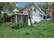 Charming home with a screened-in porch and lush landscaping creating a private outdoor space at 1630 Lakeview Ct, Eustis, FL 32726