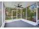 Relaxing screened porch features a ceiling fan and views of the lush backyard, perfect for enjoying the outdoors at 1630 Lakeview Ct, Eustis, FL 32726