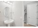 Clean powder room with pedestal sink and entry view to stairwell at 16526 Silver Brook Way, Winter Garden, FL 34787
