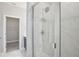 Glass-enclosed shower with chrome shower head, and view into closet at 16526 Silver Brook Way, Winter Garden, FL 34787